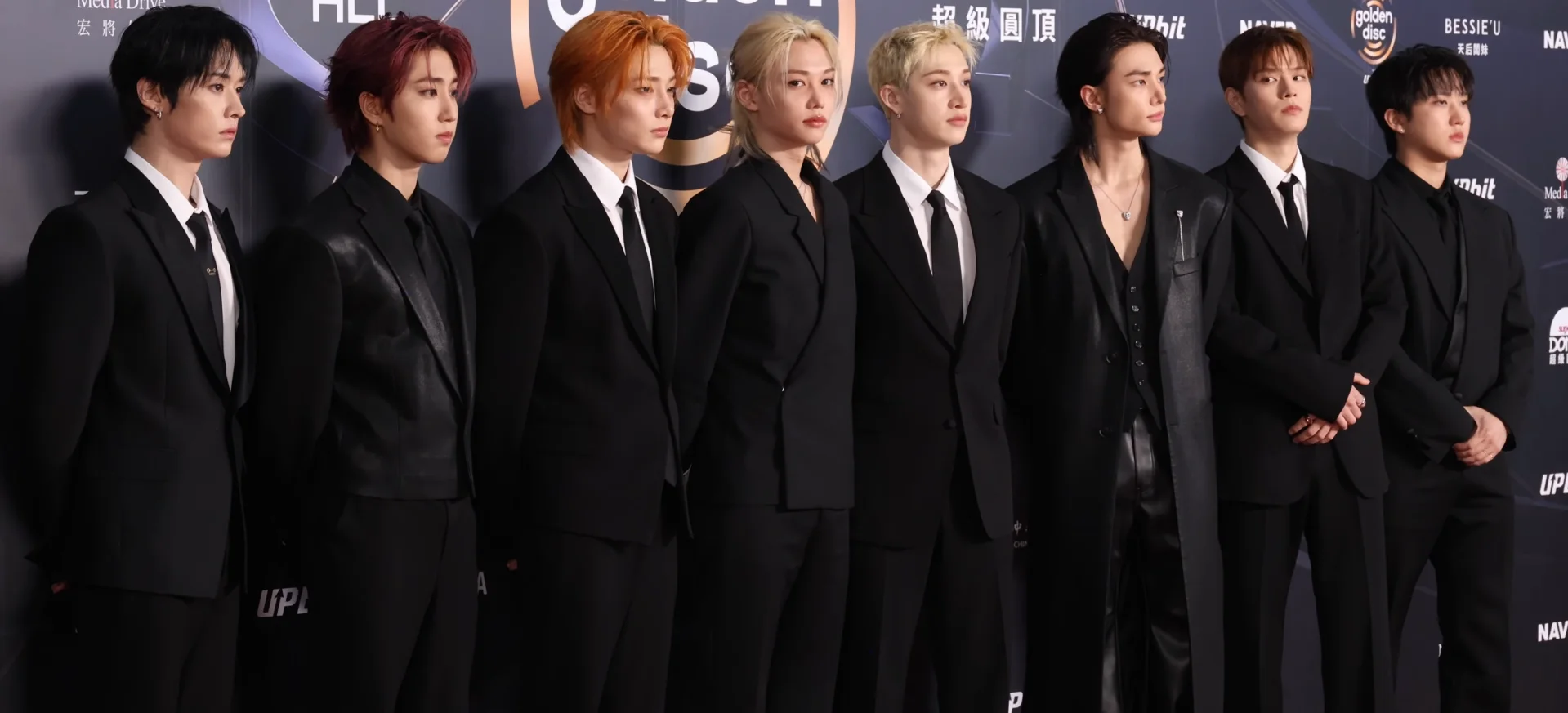 All eight Stray Kids members wearing black suits at the Golden Disc Awards in January 2026